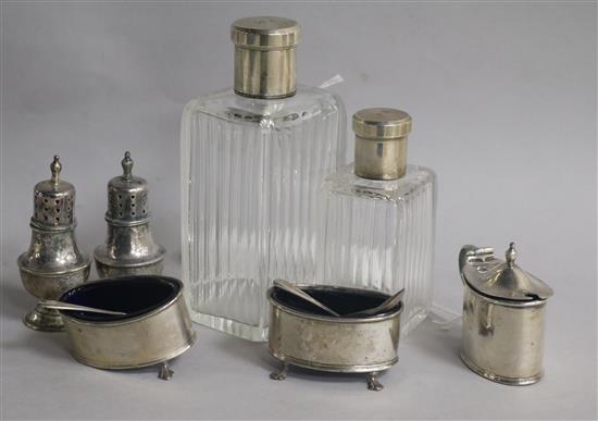 Two French silver-mounted glass toilet bottles, a silver three-piece condiment set and a pair of peppers,